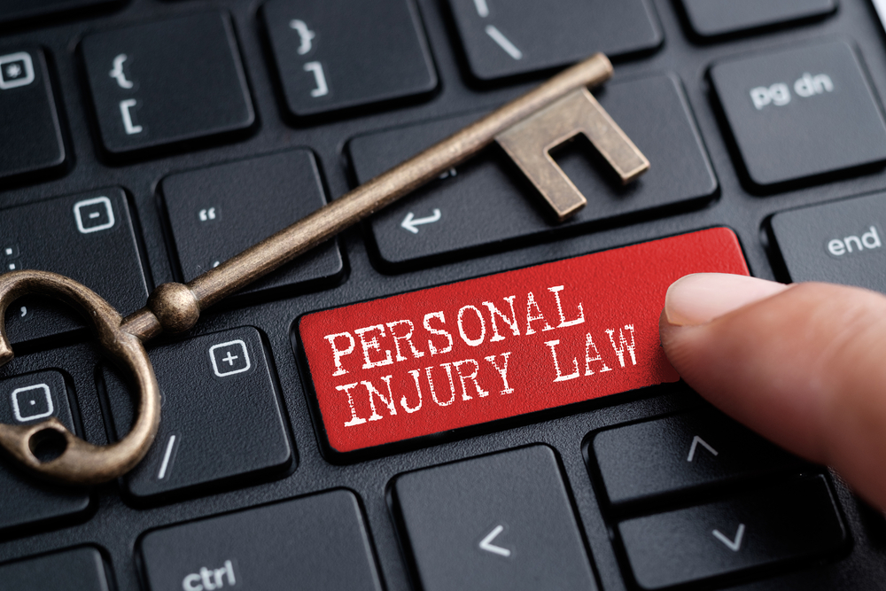 Closed up finger on keyboard with word PERSONAL INJURY LAW