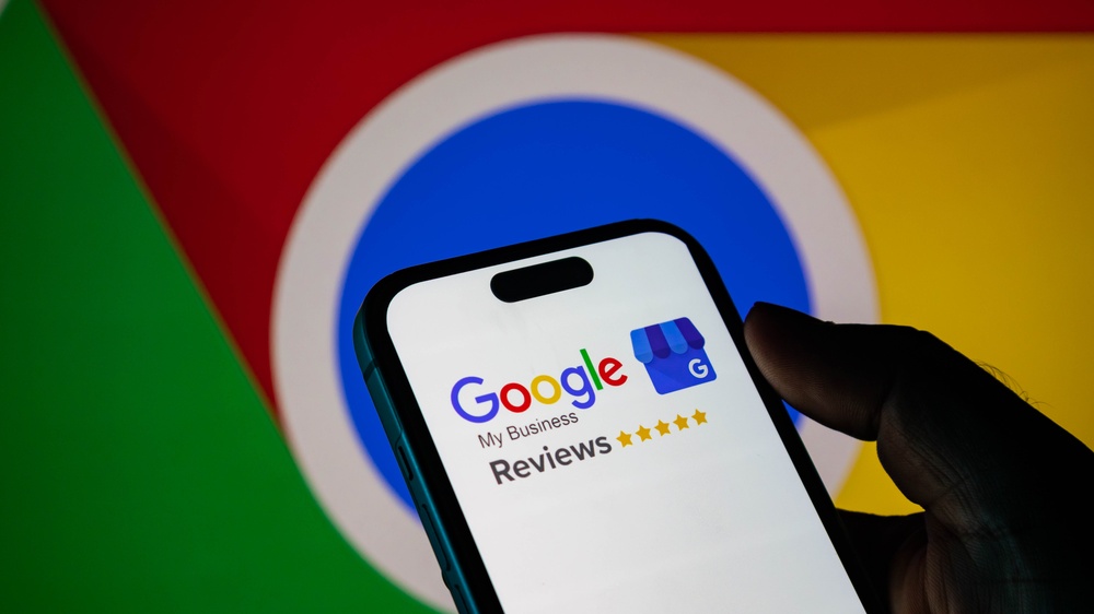 Closeup of a smartphone displaying the google my business reviews logo against a blurred google chrome background 