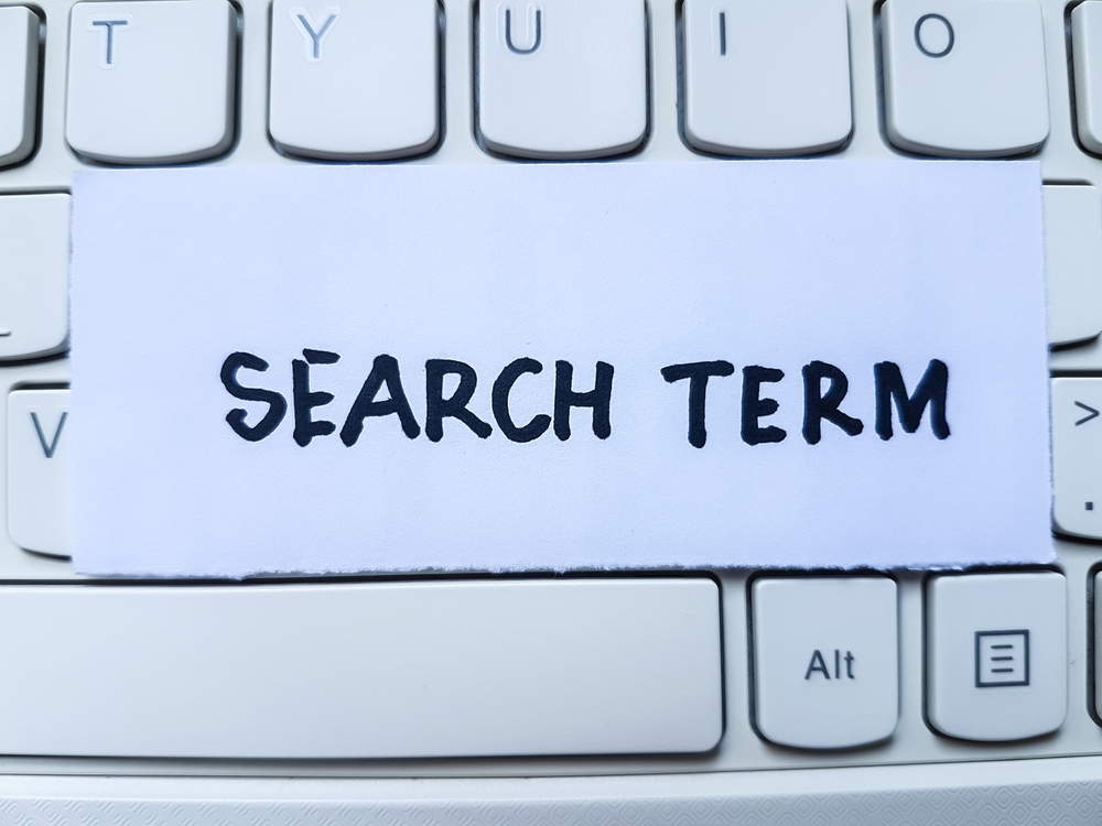 Search term writting on laptop keyboard background.